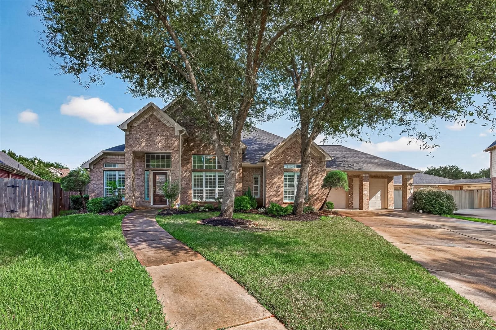The front of 506 Pearlstone Ct, set back under mature oaks
