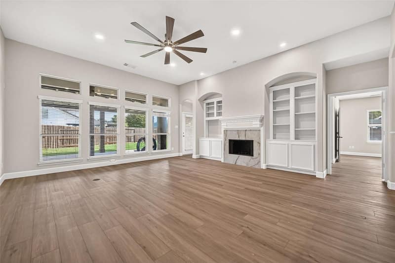 Living room with a marble fireplace flanked by white built-ins