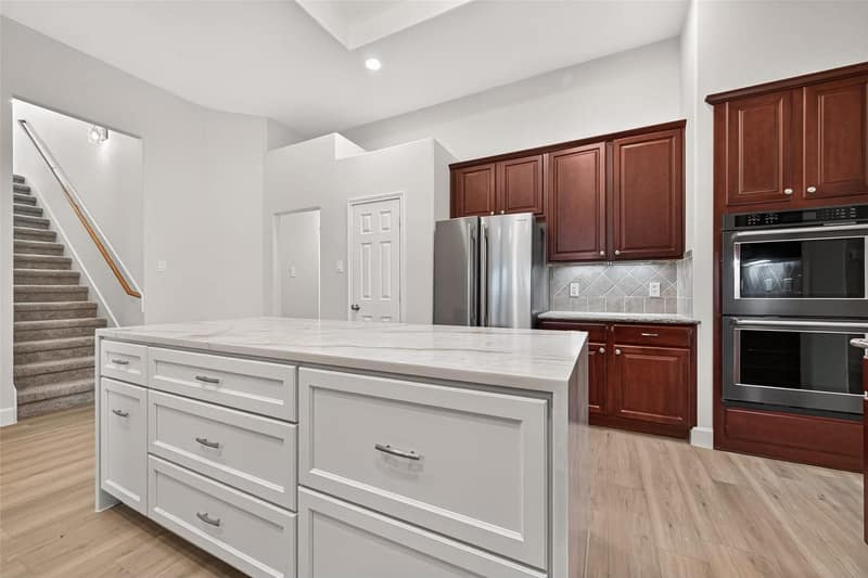 Kitchen island with double ovens and the staircase beyond